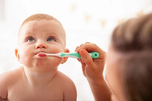 Baby brushing teeth with Brush Baby First Toothbrush