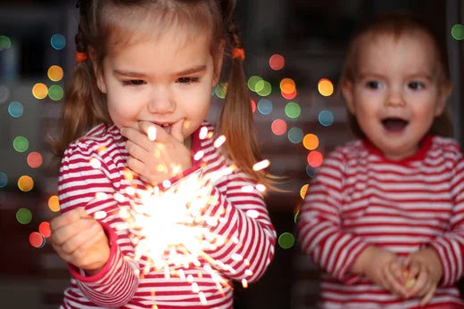 children with matching red and white stripey tops holding a sparkler | BrushBaby Toothbrushes